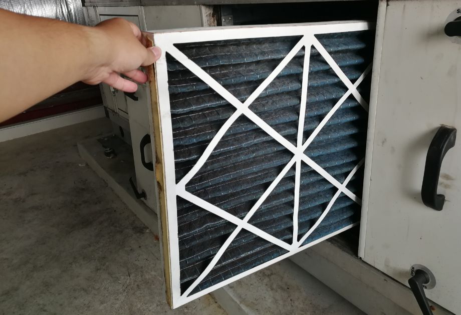 A person holding an air filter in their hand.
