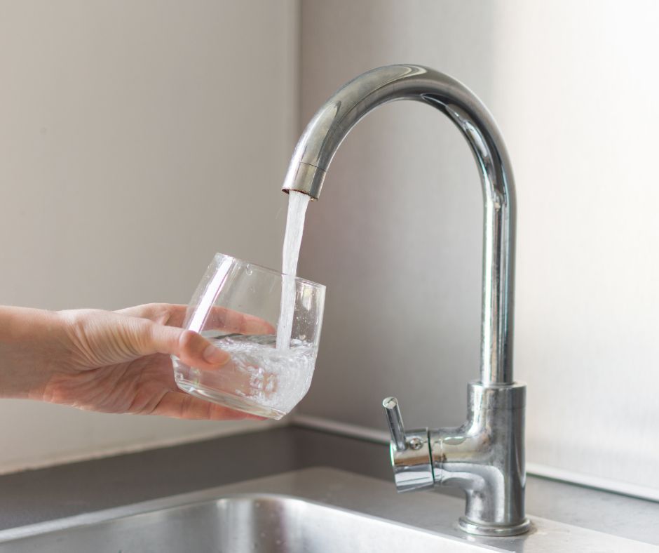 clear water glass filling with water from kitchen faucet