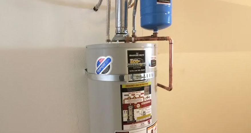 A Bradford White tank water heater with a blue thermal expansion tank and copper piping.