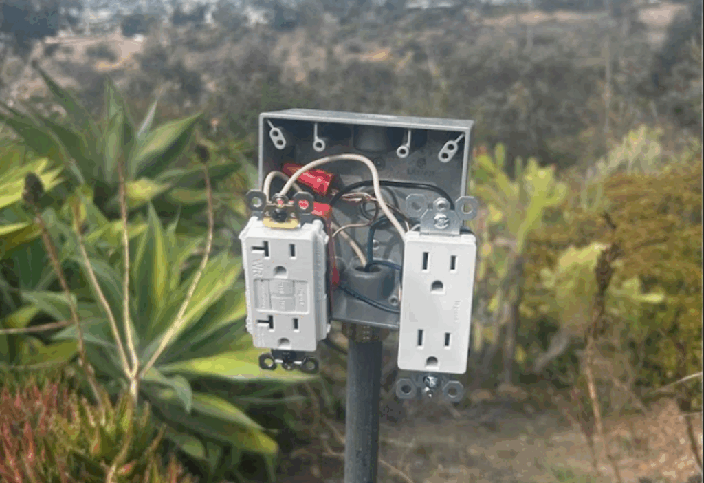 Outdoor electrical box with GFCI and standard outlet during installation.