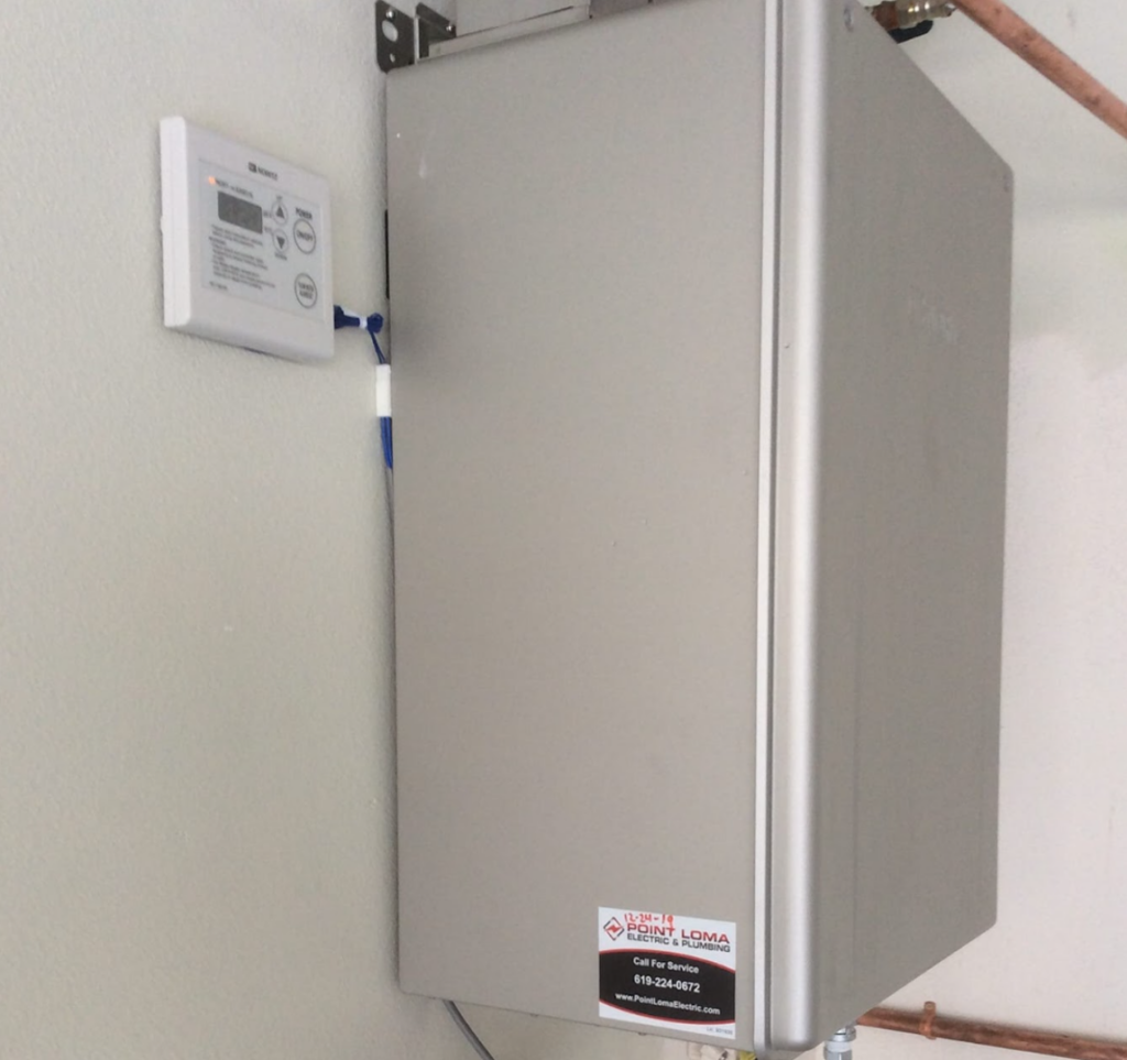 A silver Noritz tankless water heater mounted on a wall