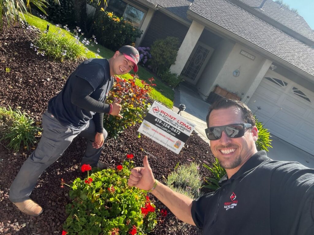 Point Loma technicians giving thumbs up in front of a home with a company yard sign