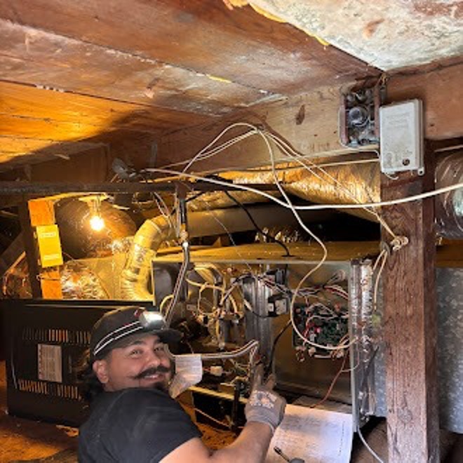 A Point Loma Home Pros technician working on a furnace