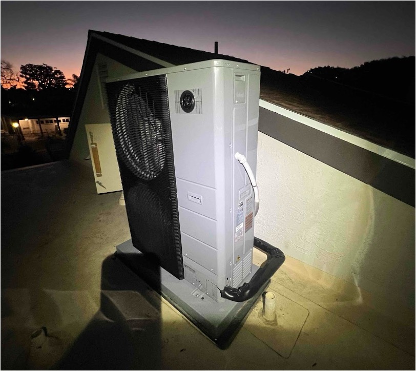 A newly installed HVAC outdoor unit mounted on a rooftop pad.