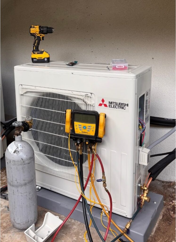 An AC unit is undergoing refrigerant diagnostics with professional tools and equipment connected to the system.