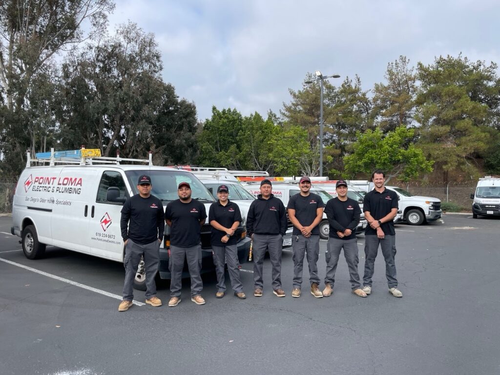 Point Loma Home Pros electricians and technicians lined up in front of their fleet of service vehicles in San Diego.