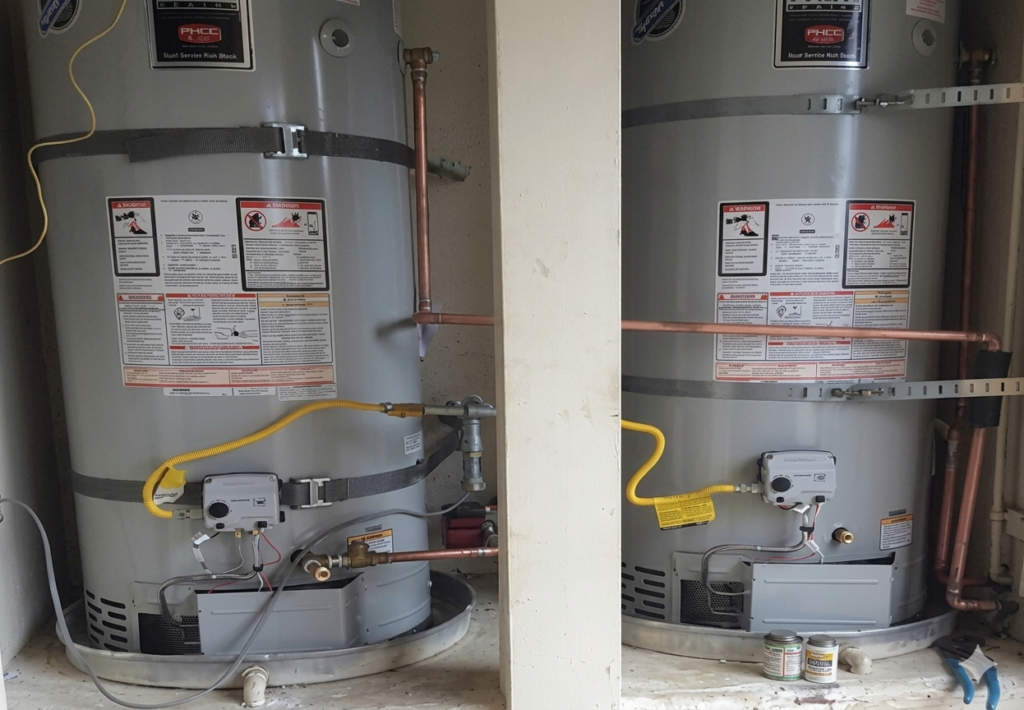 Two large water heaters installed with copper piping, gas lines, and safety valves