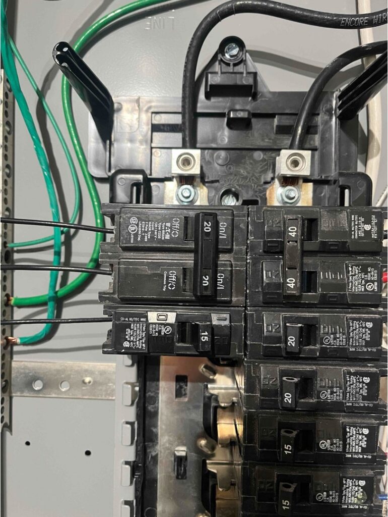 A breaker panel showing the main lugs and a mix of 20A, 40A, and 15A AFCI circuit breakers.