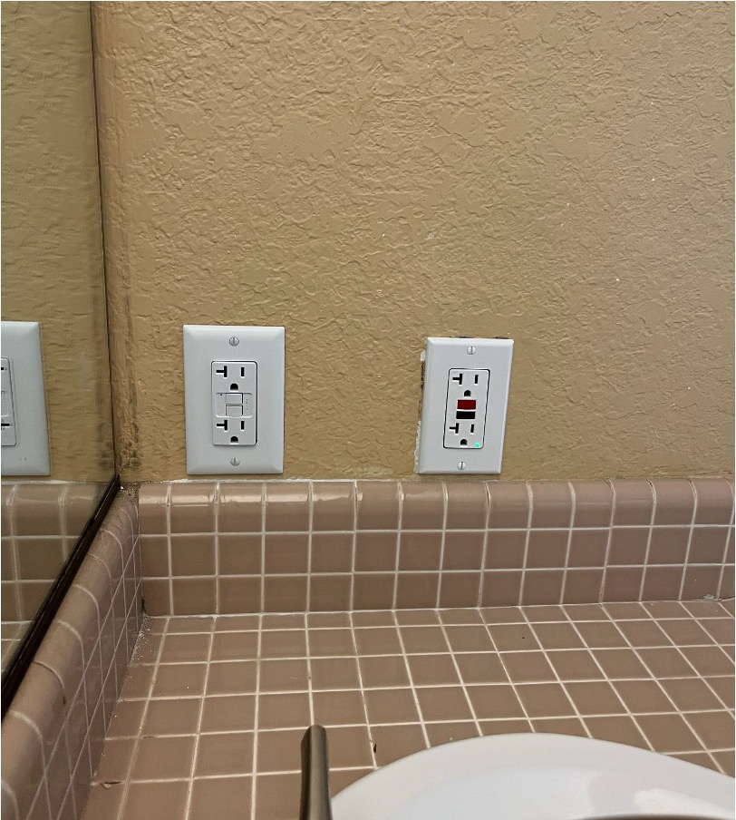 GFCI outlet installed near a bathroom sink to replace an unsafe standard outlet