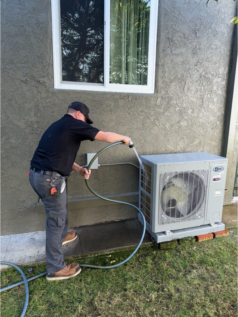 Licensed HVAC technician servicing an outdoor mini split unit.