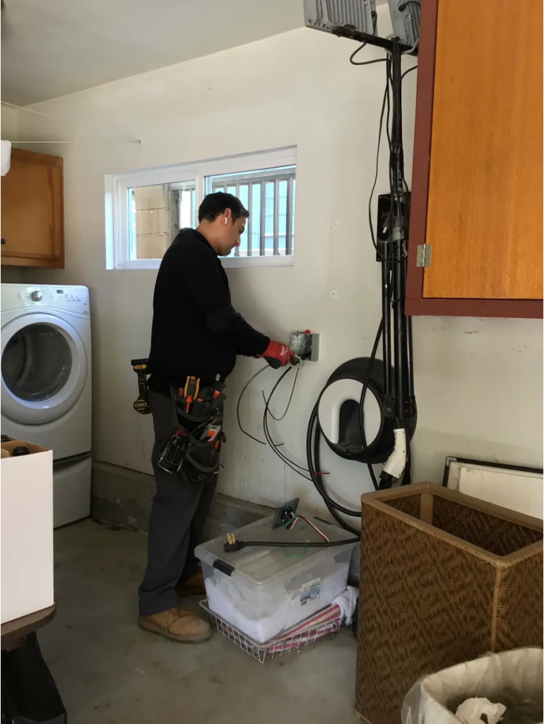 Licensed electrician installing an EV charger outlet in a residential garage
