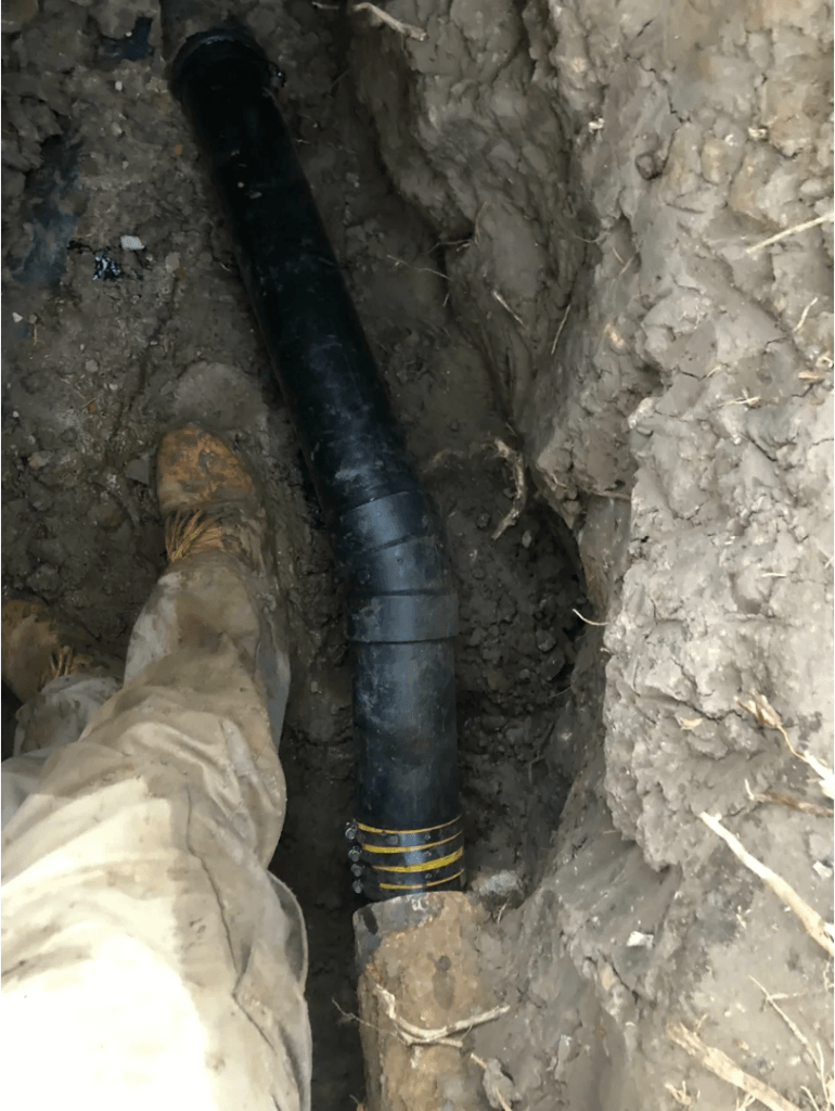 New ABS sewer pipe installed in an excavated trench during a residential sewer line replacement