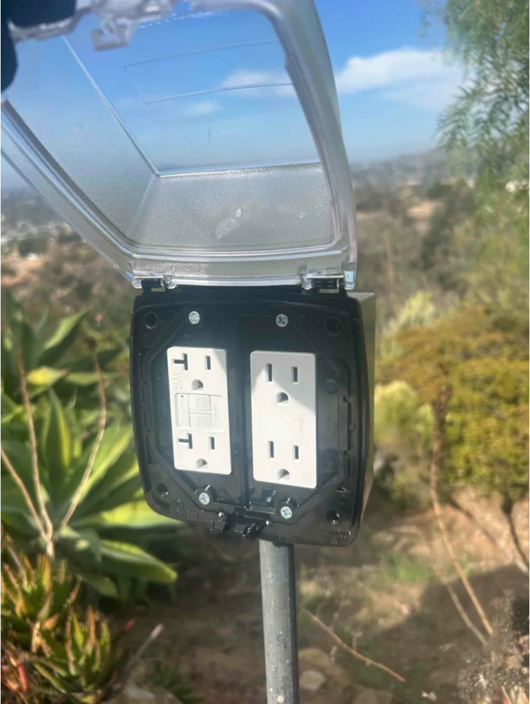 Weatherproof outdoor GFCI outlet box installed on a San Diego home exterior