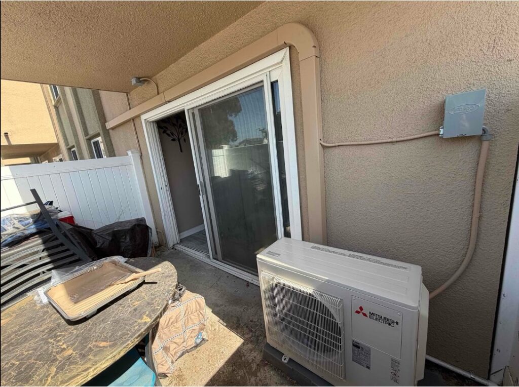 An outdoor ductless mini-split heat pump unit on a patio.