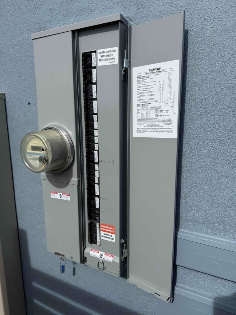 Open exterior meter-main electrical panel with an electric meter.
