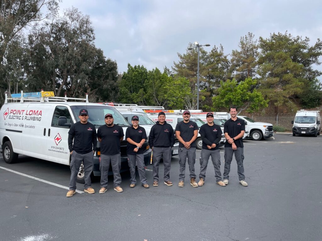 The Point Loma Home Pros team standing in front of a row of company service vans.
