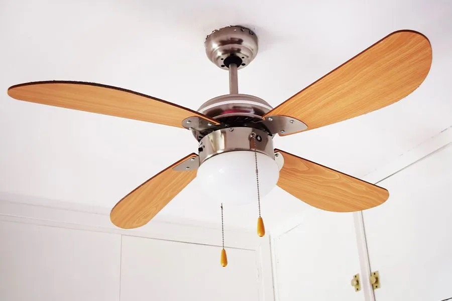 Ceiling fan with four wooden blades, brushed nickel motor, frosted glass light, and two pull chains installed by Point Loma Home Pros